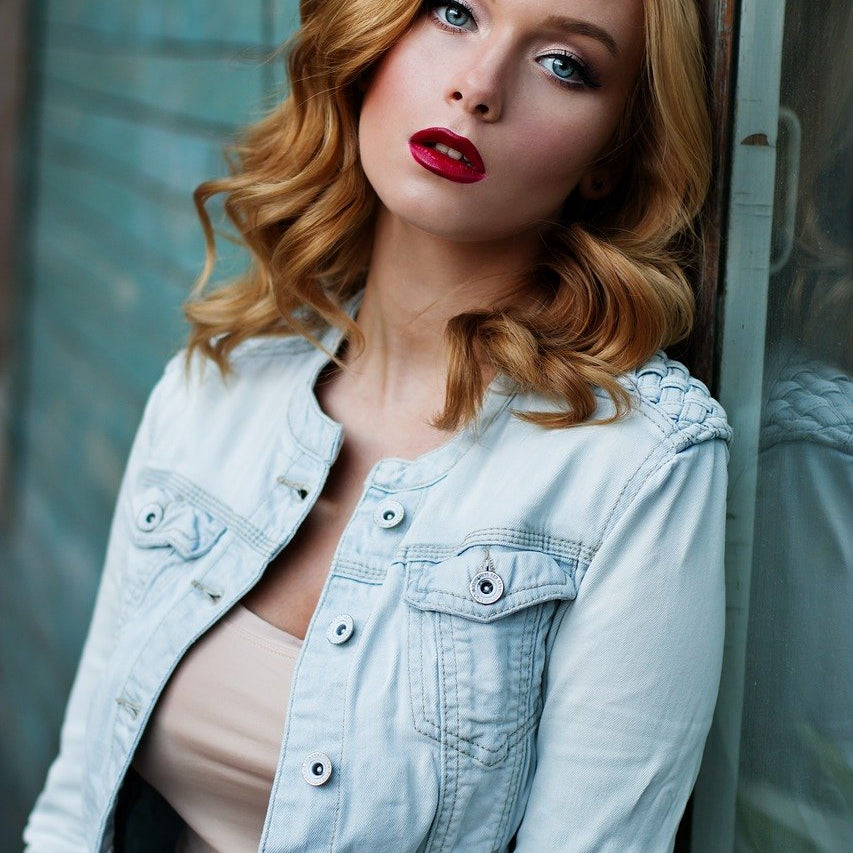 a woman with red hair styled in elegant loose waves