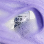 A bottle of Giovanni Cosmetics COLOR CHIC™ PURPLE LEAVE-IN HAIR STYLING & TONING FOAM, nestled in foamy lavender liquid rich in purple pigments and bubbles, helps neutralize brassy tones while providing a soft texture.