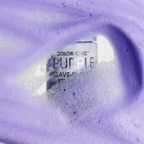 A bottle of Giovanni Cosmetics COLOR CHIC™ PURPLE LEAVE-IN HAIR STYLING & TONING FOAM, nestled in foamy lavender liquid rich in purple pigments and bubbles, helps neutralize brassy tones while providing a soft texture.