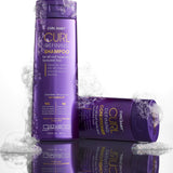 Two purple bottles of Giovanni Cosmetics CURL HABIT™ Curl Defining Shampoo, in two sizes and infused with moisturizing oils for curls, rest on a white background with playful bubbles—one upright, one lying on its side.