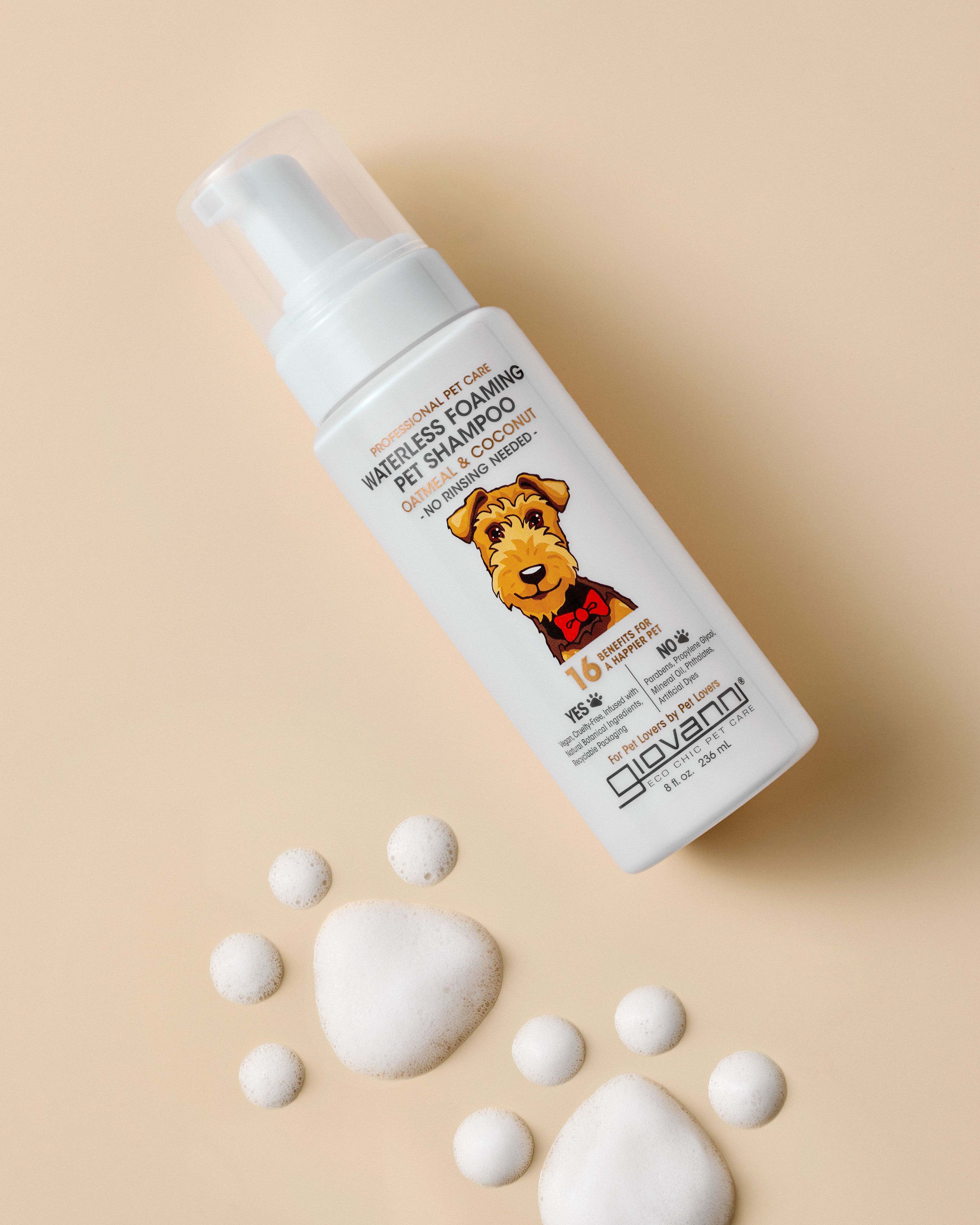 Giovanni Cosmetics PROFESSIONAL WATERLESS FOAMING PET SHAMPOO - OATMEAL & COCONUT features an illustrated dog on the label, surrounded by foam bubbles on a beige background—ideal for pets needing gentle, sensitive skin care.