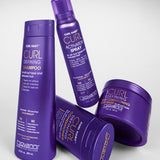 Four Giovanni Cosmetics CURL HABIT™ Curl Defining Shampoos in purple bottles, designed to moisturize and define curls, are arranged on a white surface.
