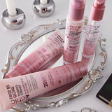 Pink hair care products on a decorative tray with candles in the background