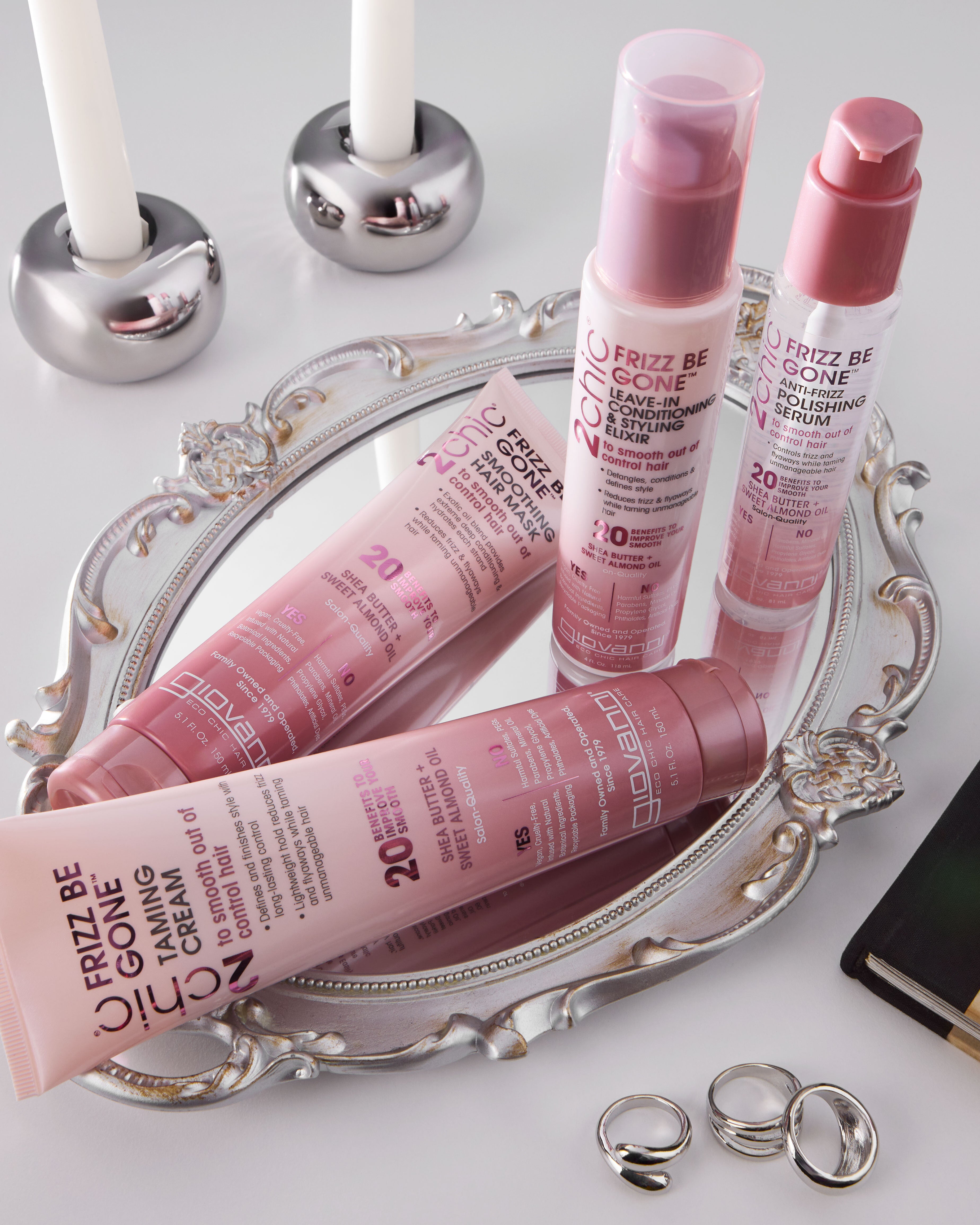 Pink hair care products on a decorative tray with candles in the background