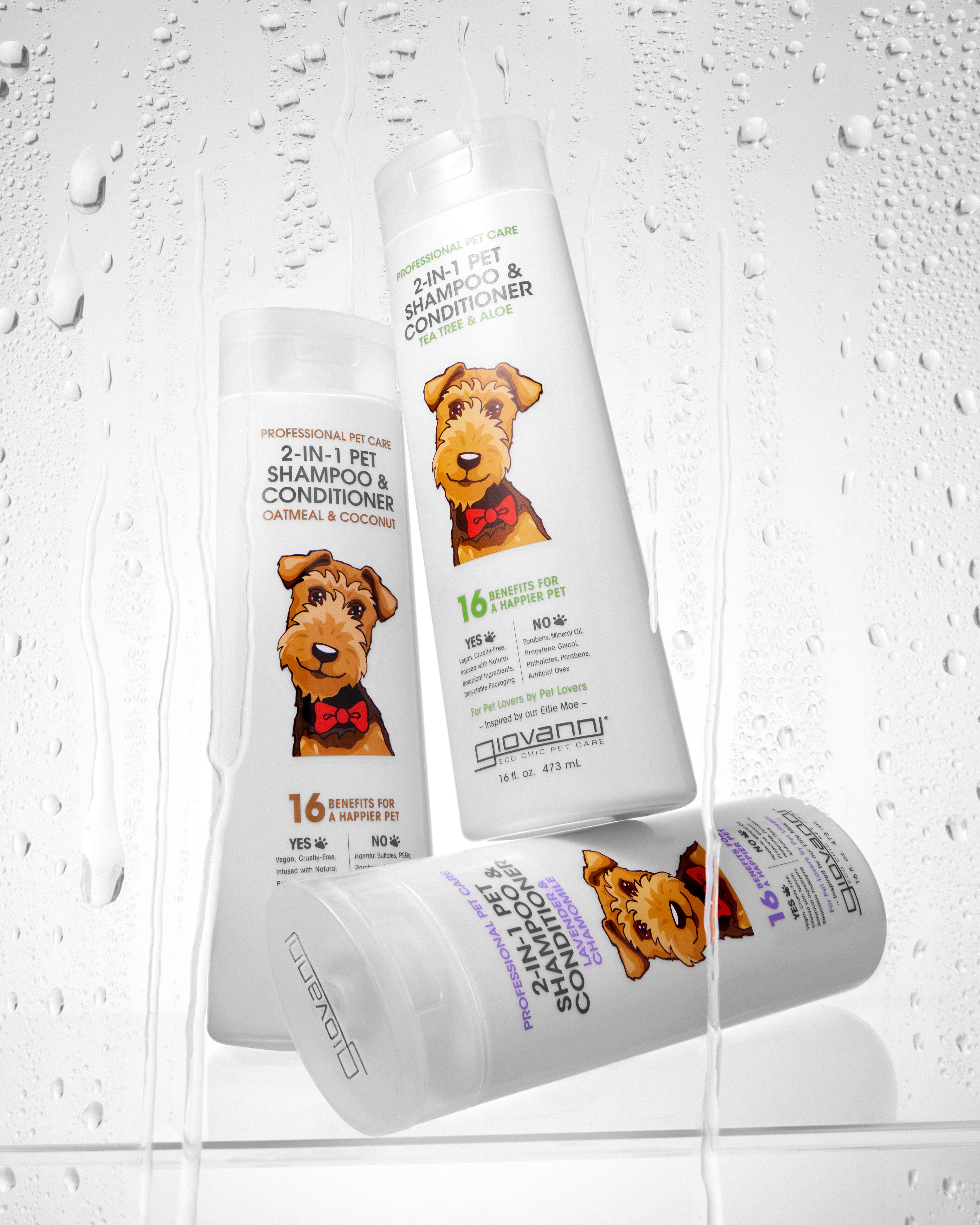 Three white bottles of Giovanni Cosmetics PROFESSIONAL 2-IN-1 PET SHAMPOO & CONDITIONER, each labeled with a cartoon dog in a red bow tie, are displayed on a wet background—perfect for pets needing sensitive skin care.