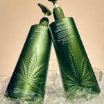 Two bottles of Giovanni Hemp Hydrating Hair Care products, including shampoo and conditioner, standing in a fluffy pile of bubbles against a warm beige background.
