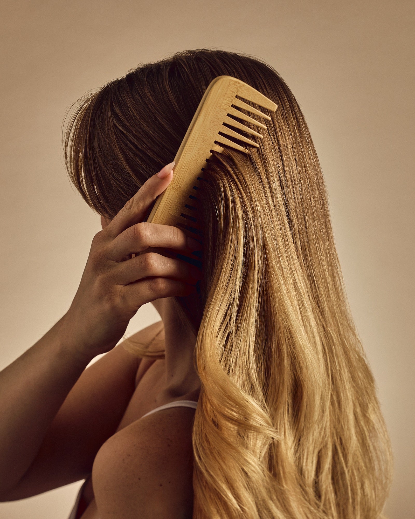 Giovanni Bamboo comb being used to comb blond hair.
