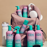 Eco Chic KIDS Collection arranged in front of and inside a dusty pink backpack, with white over-ear headphones resting on top. The products include hair care items like shampoo, conditioner and body wash.