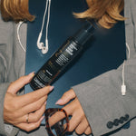 Image of woman holding bottle of Giovanni Professional Hair Serum