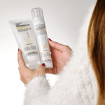 Person holding Giovanni hair care products against a white background