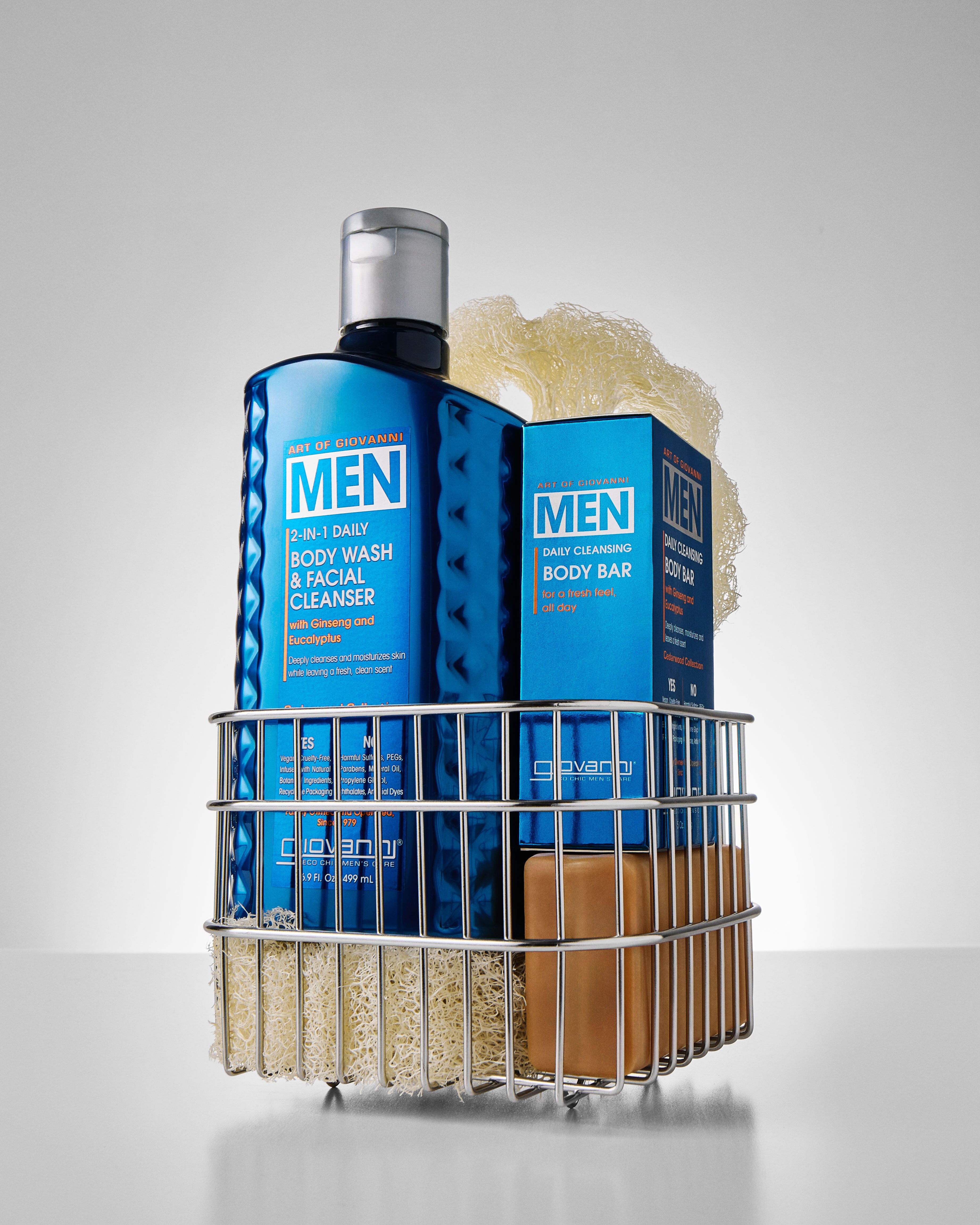 Giovannni Men's grooming products including body wash, bar soap, and a scrubber on a gray background