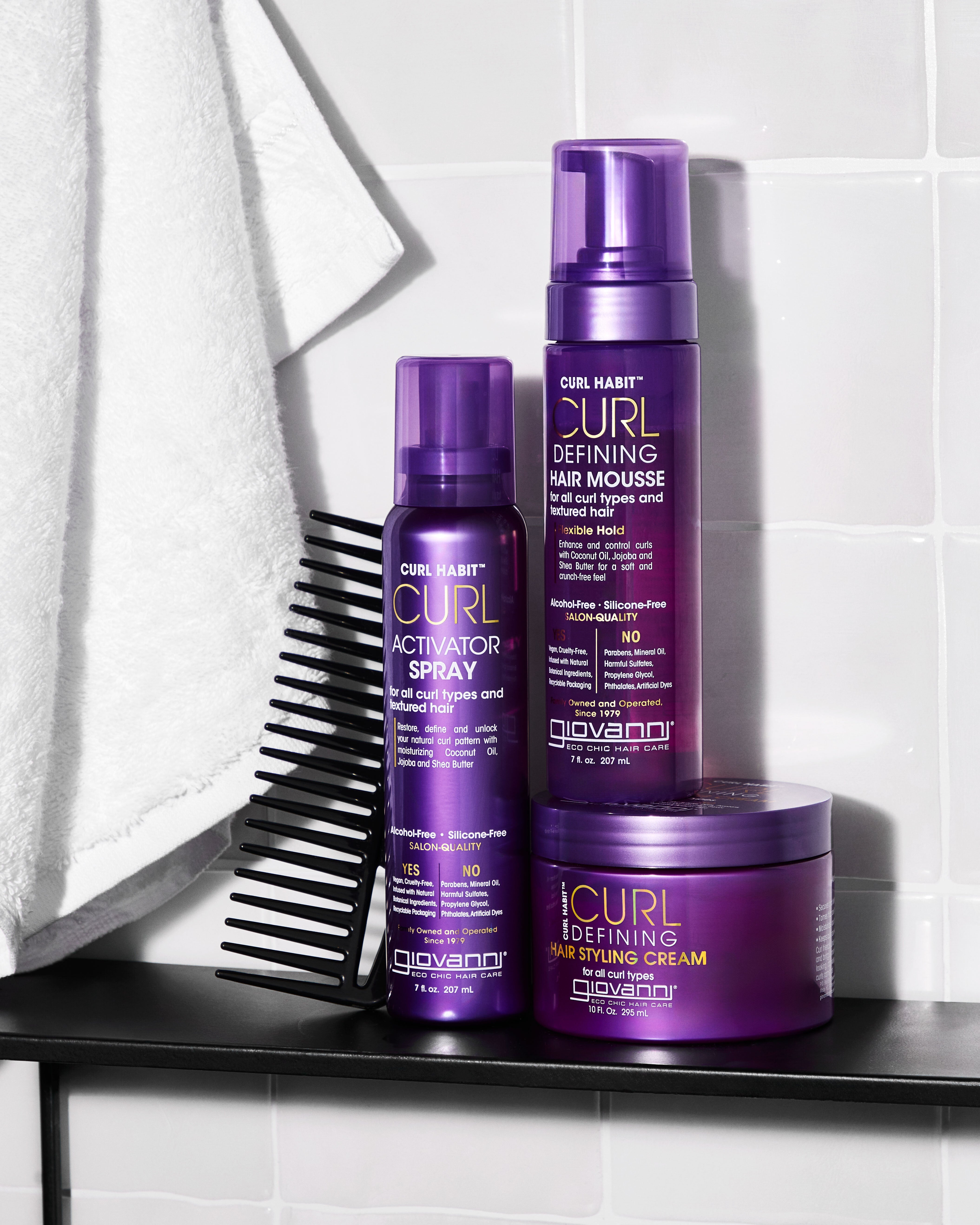 Giovanni CURL Habit products including mousse, spray, and cream on a shelf with a comb.