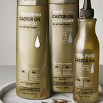 Giovanni Smoothing Castor Oil shampoo, conditioner, and oil on a white surface with gold jewelry.