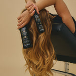 Giovanni model sitting in salon chair with back to camera holding Professional Collection products