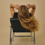 Giovanni model sitting in chair with back to camera
