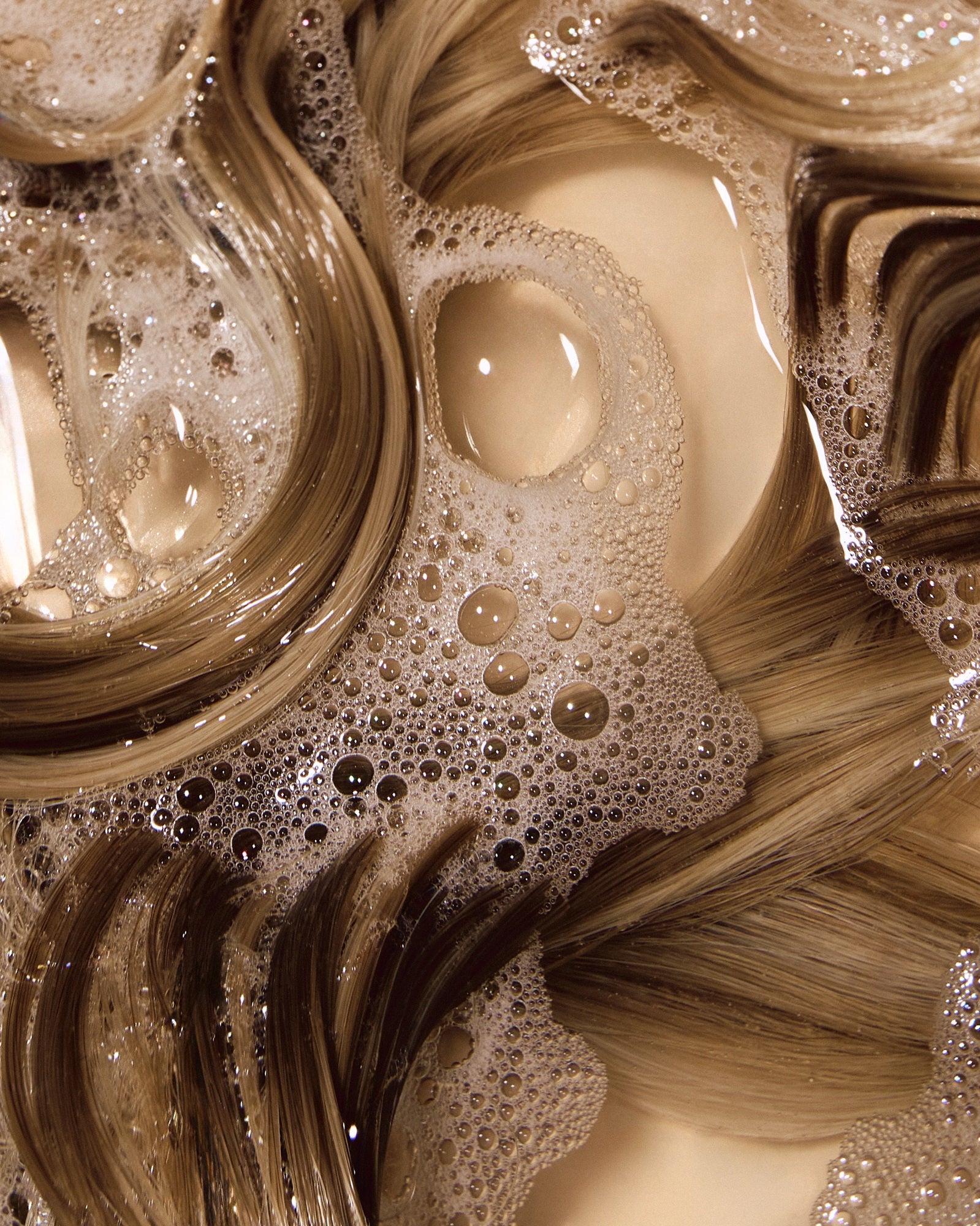 Close-up of blonde hair during a salon shampoo rinse.