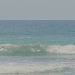 Video of woman on beautiful beach applying 2chic® ULTRA-SLEEK HAIR & BODY SUPER POTION OIL to her long brown hair.